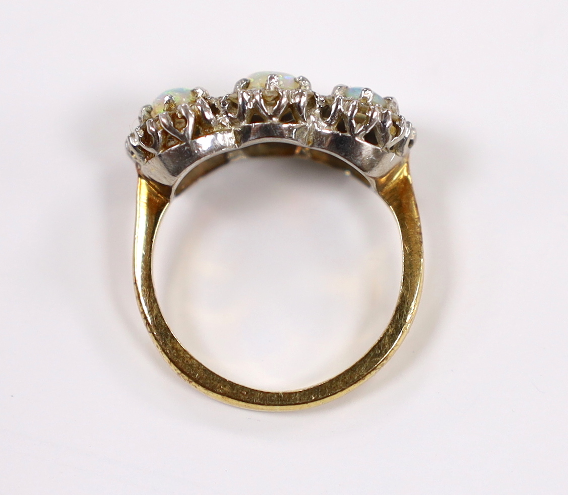An 18ct, white opal and diamond chip set triple cluster dress ring, size K, gross weight 4.2 grams.